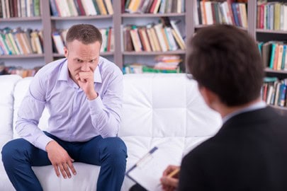 Depressed man talking to his psychologist about addiction