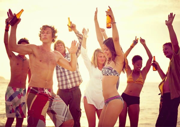 College students drinking alcohol on beach