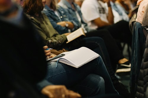 image of people sitting in a group to symbolize the question does aa do more harm than good