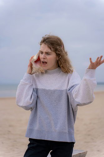 image of a woman using a conch shell to file complaints about addiction treatment in california